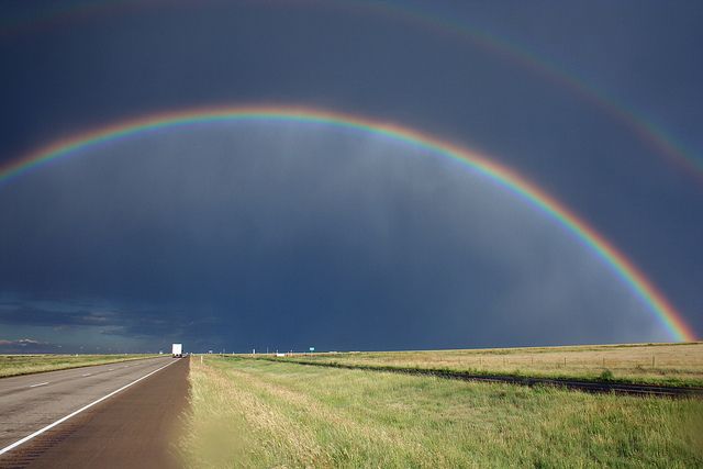 A double rainbow over an empty stretch of highway